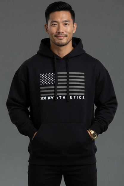 Man wearing a black hoodie with a flag design and 'XXXY Athletics' text on a gray background || Black
