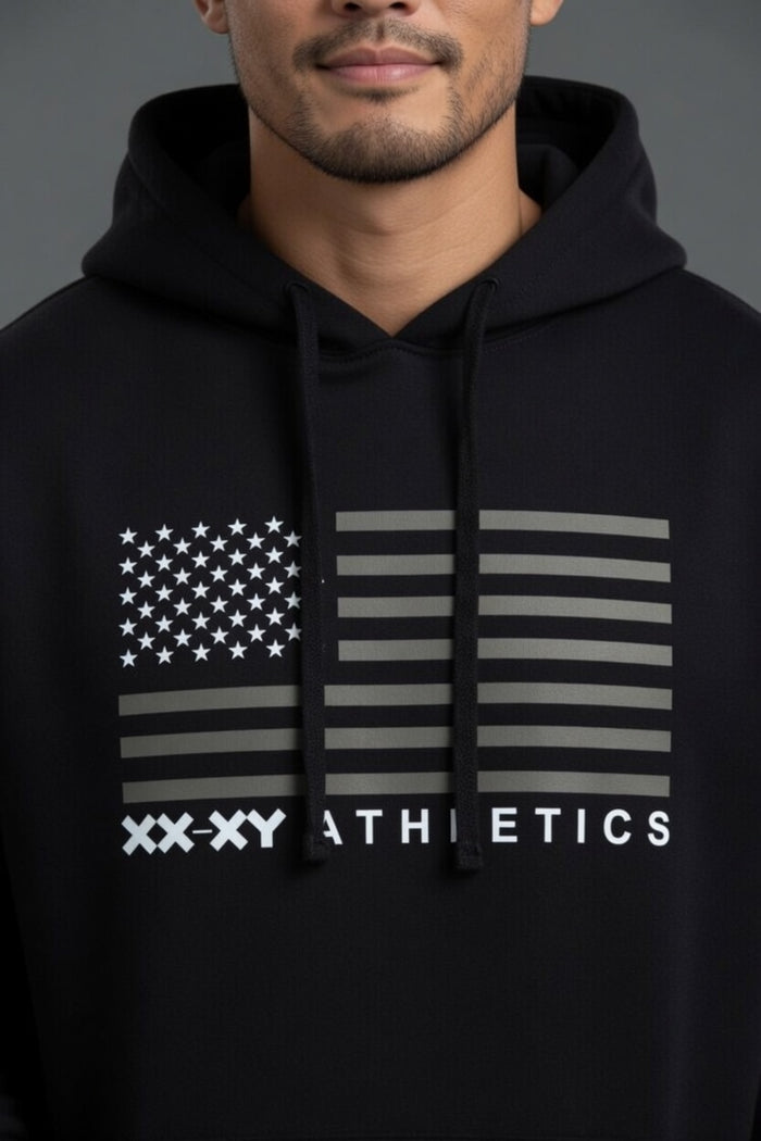 Person wearing a black hoodie with an American flag design and 'XXXY Athletics' text.  || Black