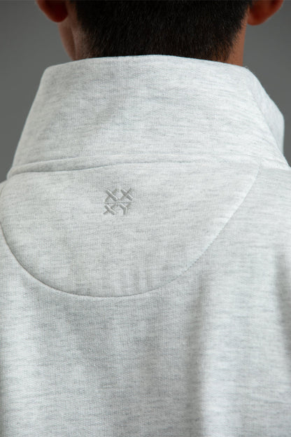 Close-up of a gray hoodie with a brand logo on the collar against a neutral background || Light Heather Gray