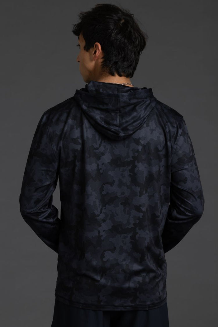 Person wearing a dark camouflage hoodie on a gray background || Black Camo
